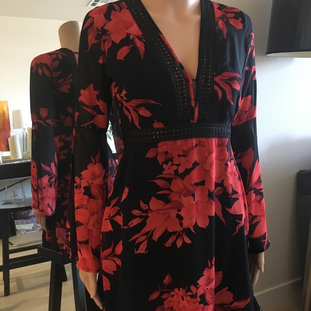 Red and black floral dress with bell sleeves .